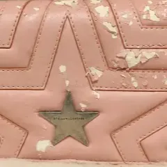 Close-up of a pink quilted bag with peeling finish